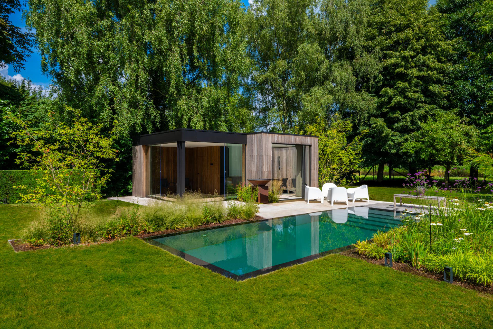 Een tijdloze tuinbeleving rond een vierzijdig overloopzwembad